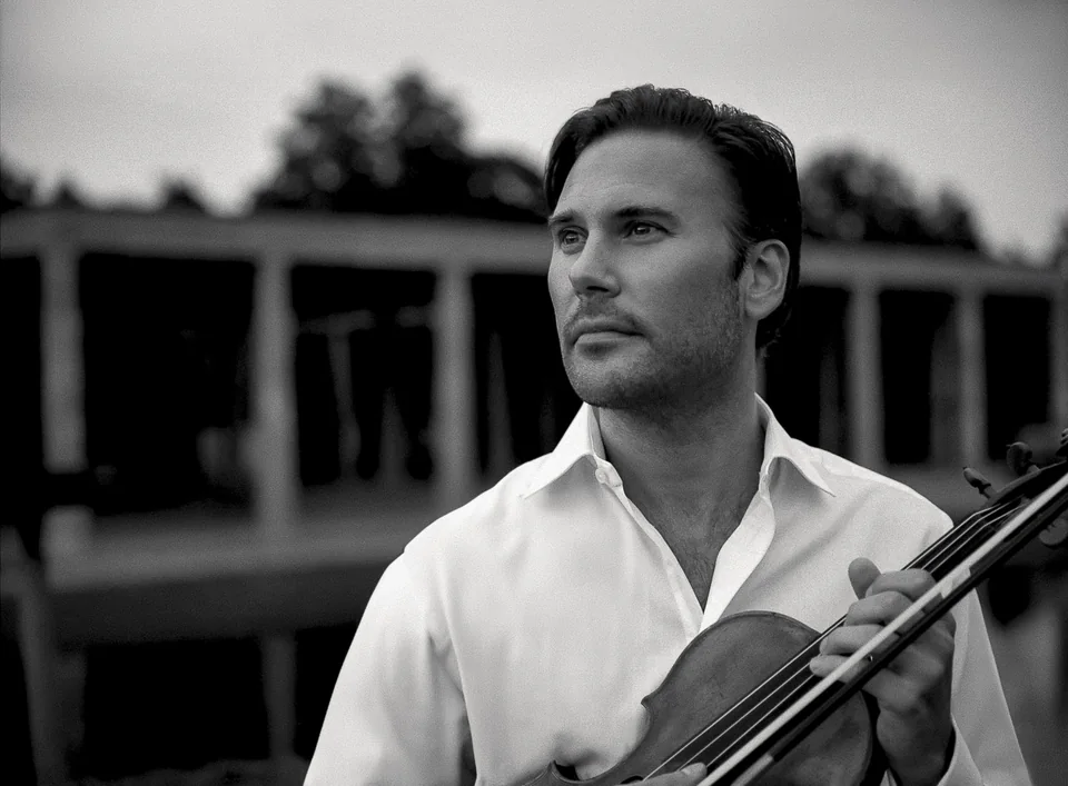 Svartvitt utomhusporträtt av Christian Svarfvar med violin