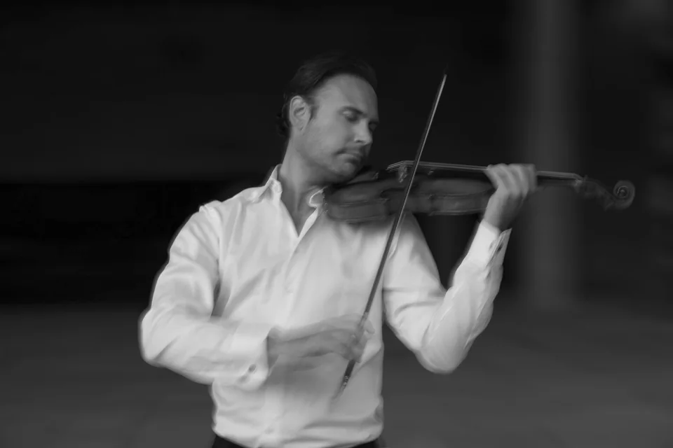 Svartvitt porträtt av Christian Svarfvar som spelar violin
