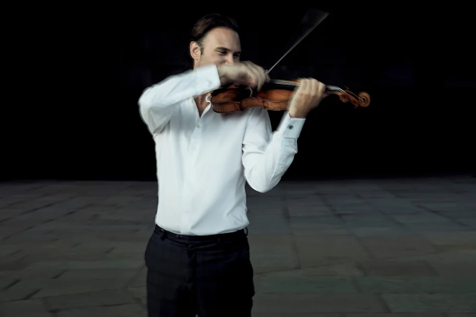 Christian Svarfvar spelar violin i vit skjorta