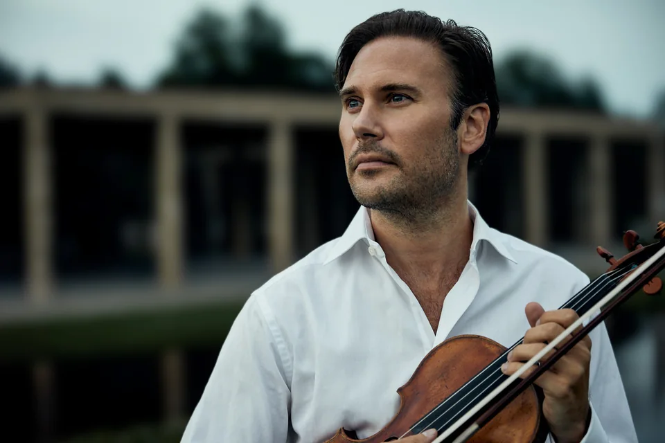 Utomhusporträtt av Christian Svarfvar med sin violin