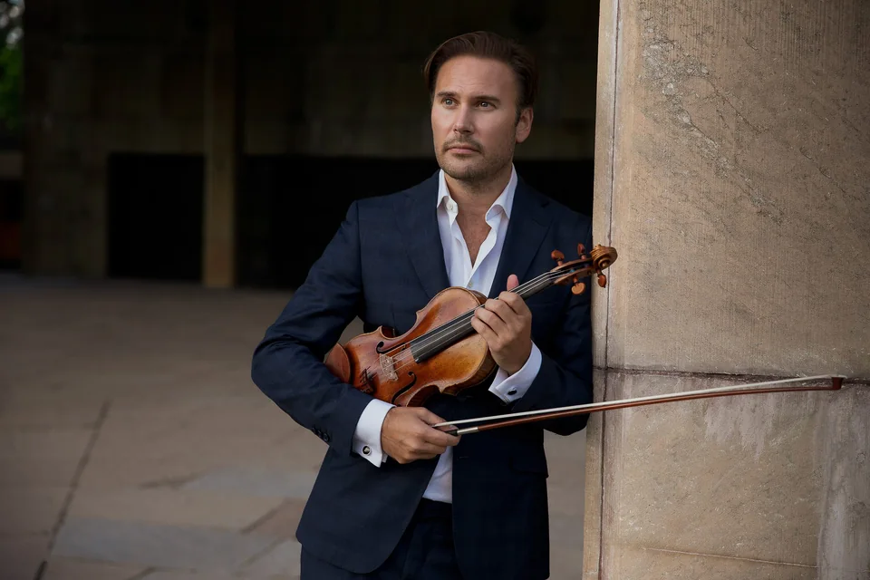 Porträtt av Christian Svarfvar med violin i blå kostym