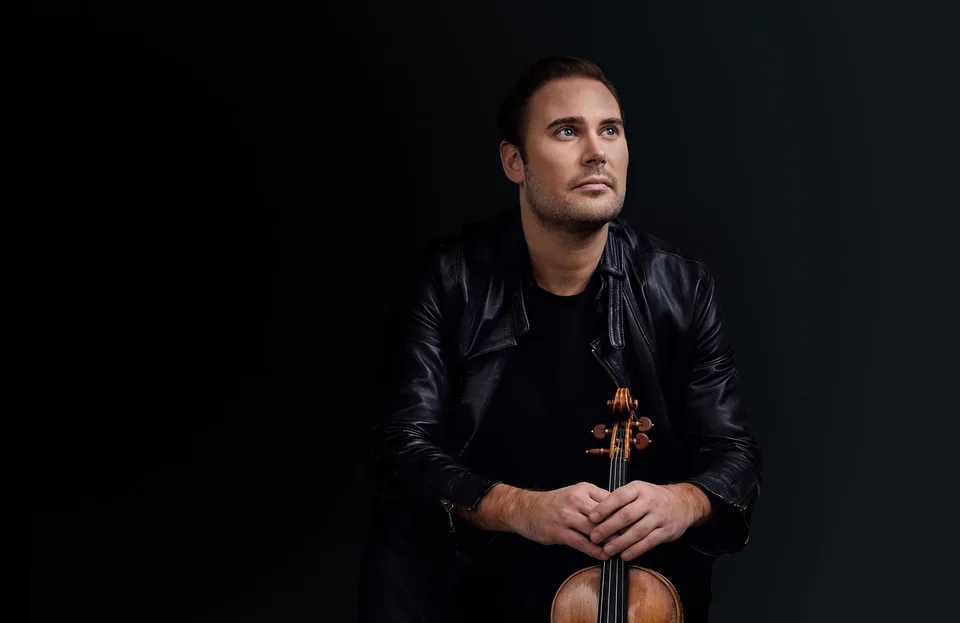 Sittande porträtt av Christian Svarfvar med sin violin